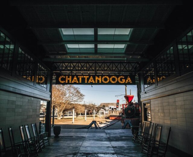 Exterior of the historic Chattanooga Choo Choo train station and hotel, with a vintage locomotive on display in front