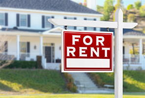 A "For Rent" sign in front of a house