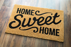 A charming "Home Sweet Home" doormat symbolizing the start of a new journey in home buying and understanding real estate jargon.