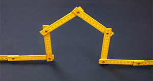 A creative tape measure shaped like a house, symbolizing the accurate measurement of a home's square footage.