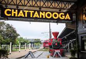 Sign displaying "CHATTANOOGA" with the historic Chattanooga Choo Choo train in the background.